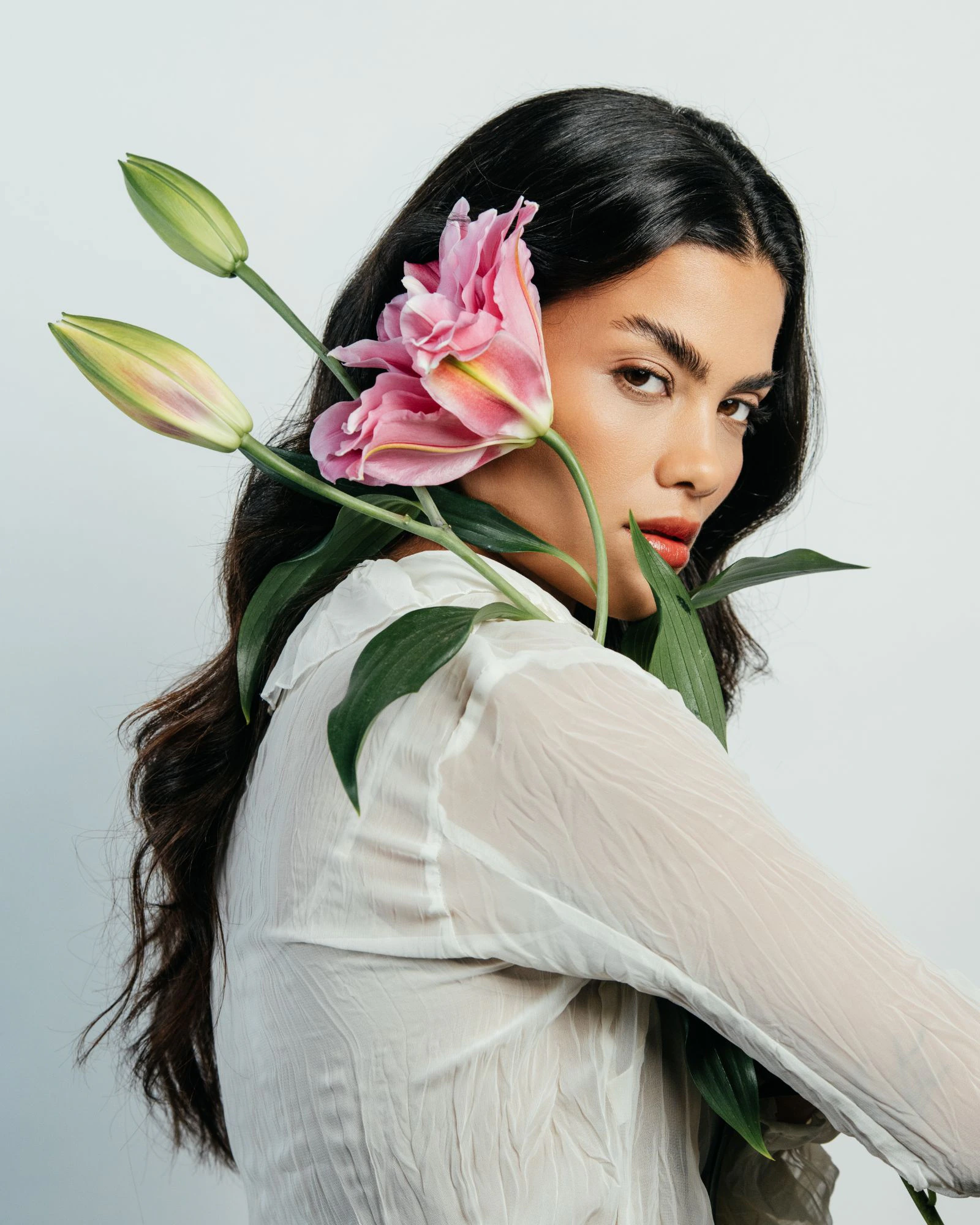 Modelo com lírios rosas sobre o ombro, Época Cosméticos Primavera 26